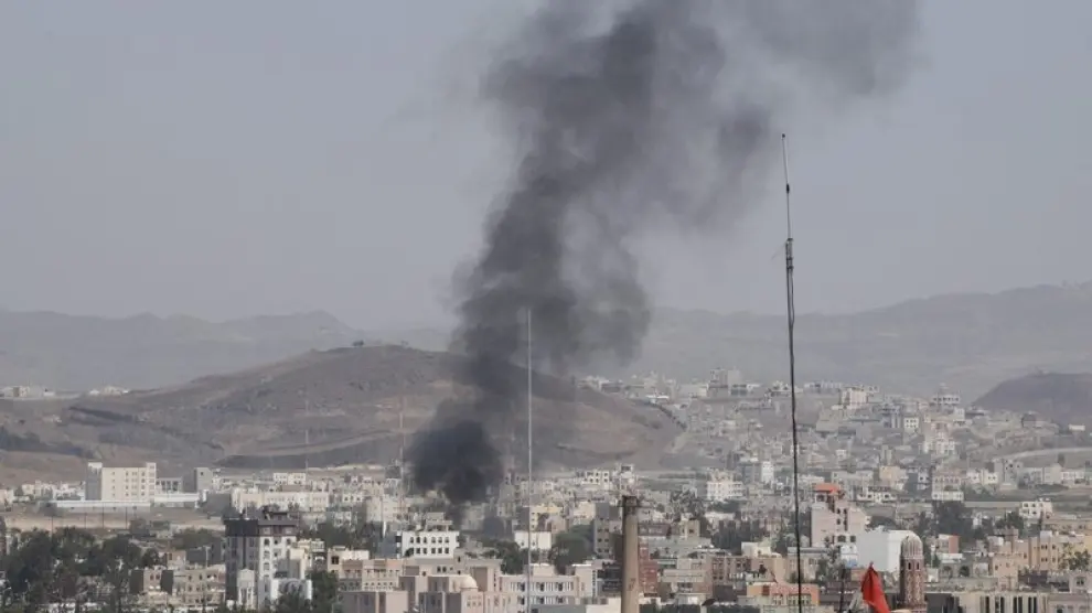 Una columna de humo emerge de un edificio durante los enfrentamientos entre las fuerzas de seguridad yemeníes y un grupo tribal armado
