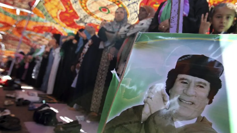 Mujeres partidarias de Muamar al Gadafi durante los rezos del mediodía este viernes