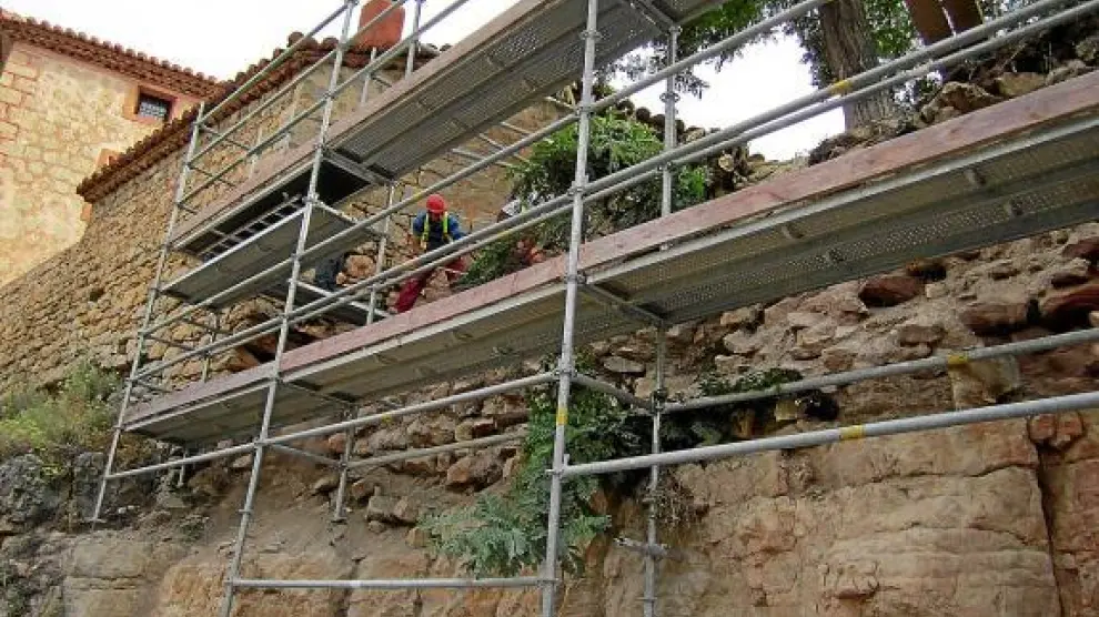 Los andamios se apoyan en el estrato rocoso. Sobre él pueden verse los restos de la muralla.