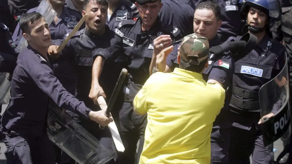 Varios policías golpean a un manifestante durante las protestas.
