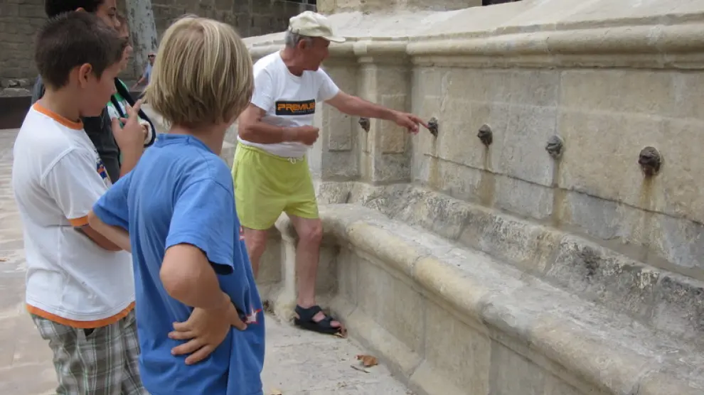 Un anciano explica a las generaciones más jóvenes la leyenda de la fuente en Alcañiz.