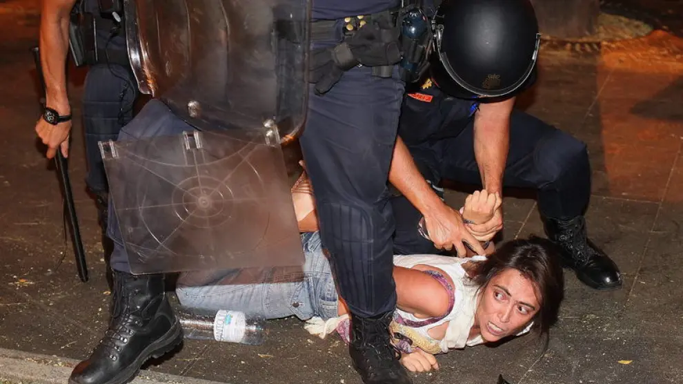 Un policía reduce a una de los manifestantes en Madrid