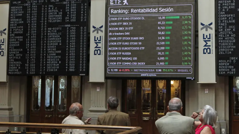 Varios operadores observan un panel en la Bolsa de Madrid
