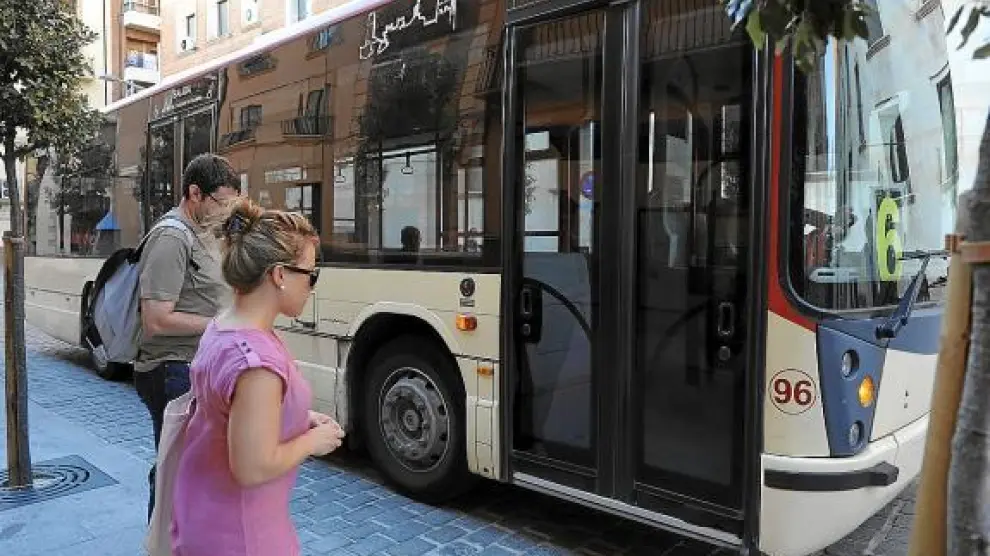 Dos usuarios toman el autobús en la calle Joaquín Arnau.