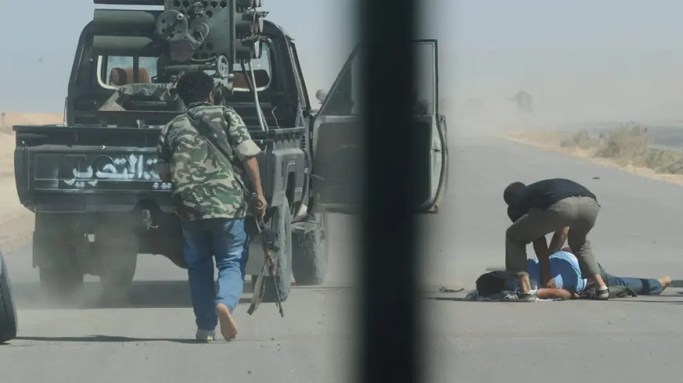 Un combatiente libio herido este martes es ayudado por sus compañeros