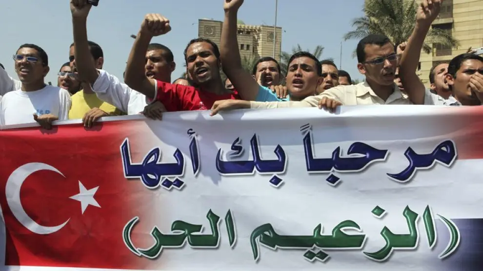 Manifestantes con una pancarta que dice en árabe "Bienvenido líder libre", para saludar al primer ministro turco en El Cairo