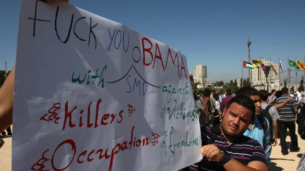 Ciudadanos palestinos portan pancartas contra el presidente estadounidense Barack Obama