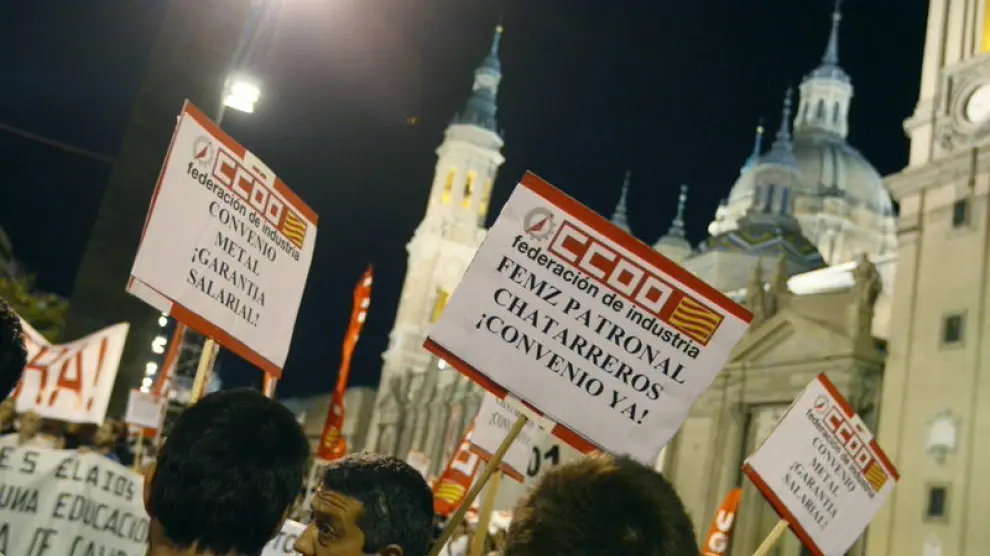 Varias personas durante la manifestación que, convocada por UGT y CCOO, ha tenido lugar hoy en Zaragoza