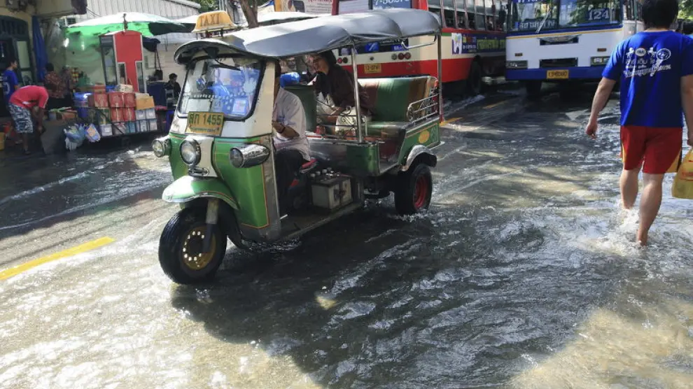 Un tuk tuk circula por las calles inundadas de Bangkok