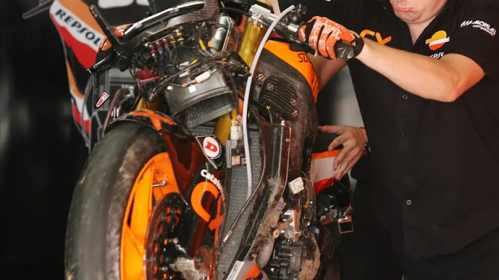 Un mecánico mueve la moto accidentada del piloto español Marc Marquez