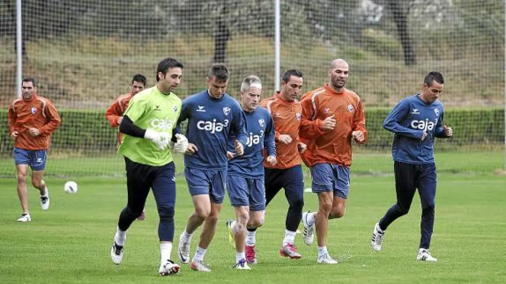 Los jugadores del Huesca realizan carrera continua, durante un entrenamiento.