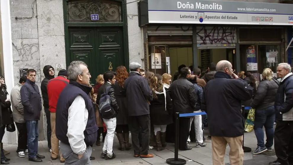 Decenas de personas esperan su turno ante una administración de lotería en Madrid