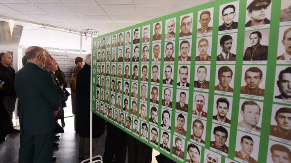 Un miembro de la Benemérita contempla un panel con las fotografías de víctimas del terrorismo