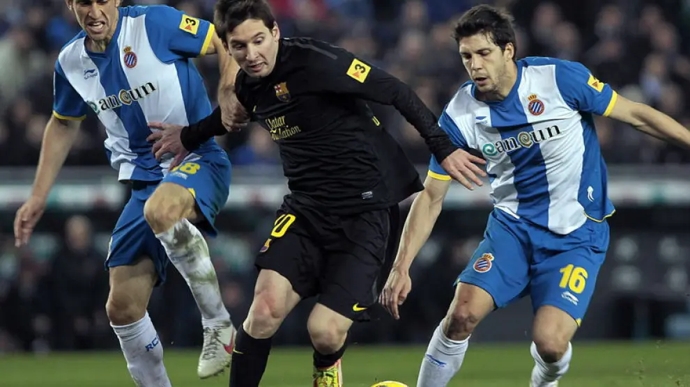 El argentino, Leo Messi, lleva el balón, ante los jugadores del Espanyol.