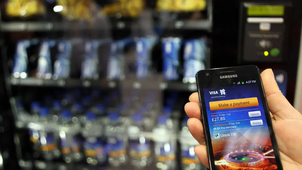 Un empleado muestra cómo comprar a través del 'smartphone' con una cuenta VISA.