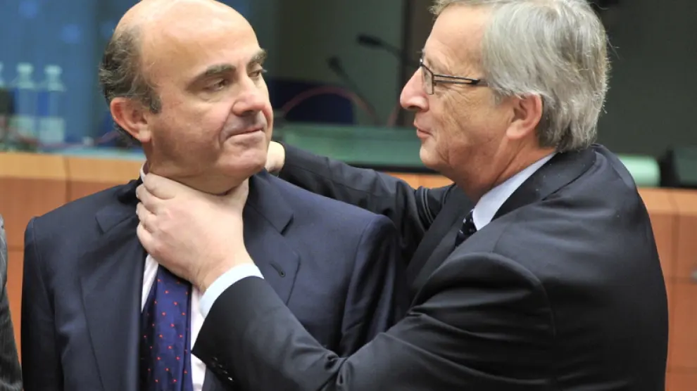 Jean-Claude Juncker y De Guindos bromean durante la reunión