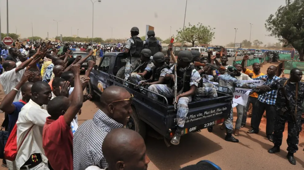 Partidarios de la Junta militar de Mali se concentran alrededor de un camión cargado con soldados.