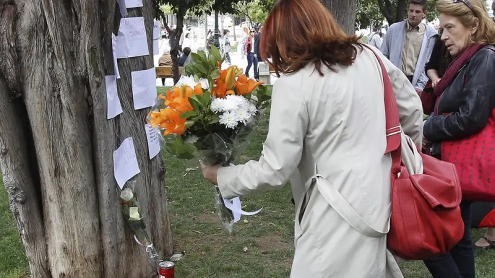 Una mujer deja un ramo de flores en el lugar de un suicidio, en Grecia.