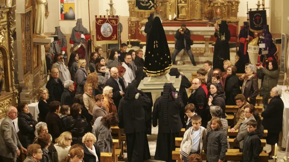 La virgen es llevada a hombros en el interior de la iglesia de Alcalá de Gurrea para protegerla de la lluvia.