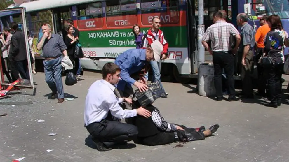 Un hombre atiende a uno de los heridos por las explosiones