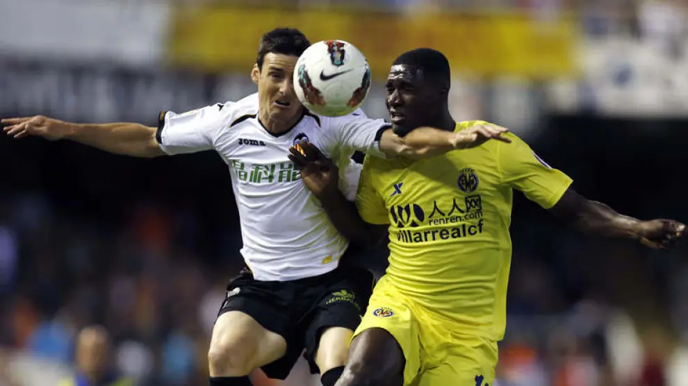 El delantero del Valencia, Aritz Aduriz, pelea por el balón con el defensa colombiano del Villarreal.