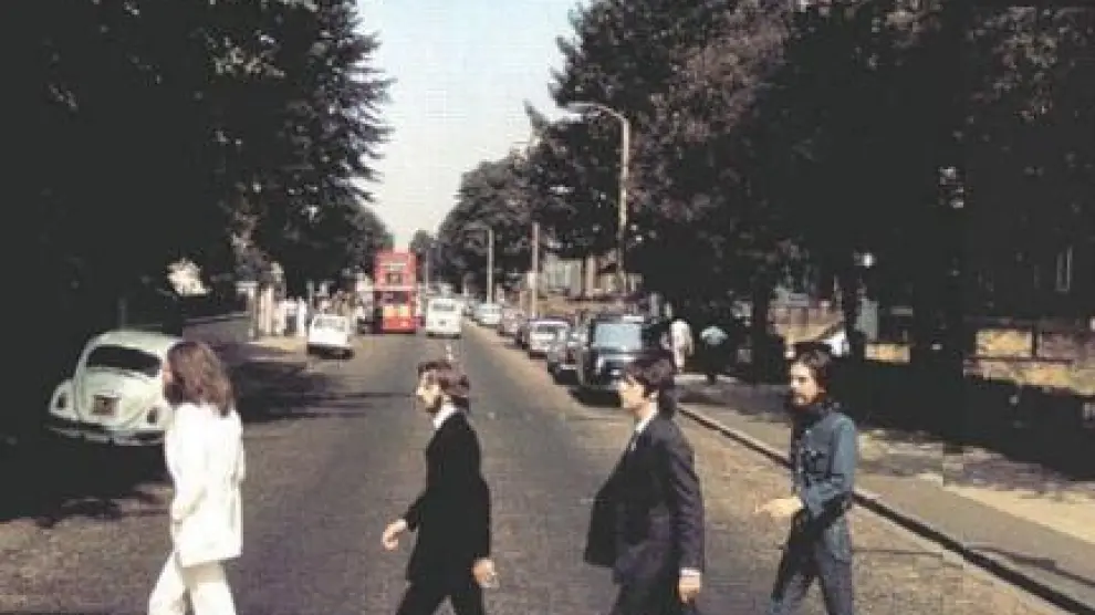 Los Beatles cruzando Abbey Road en sentido contrario a la portada del disco