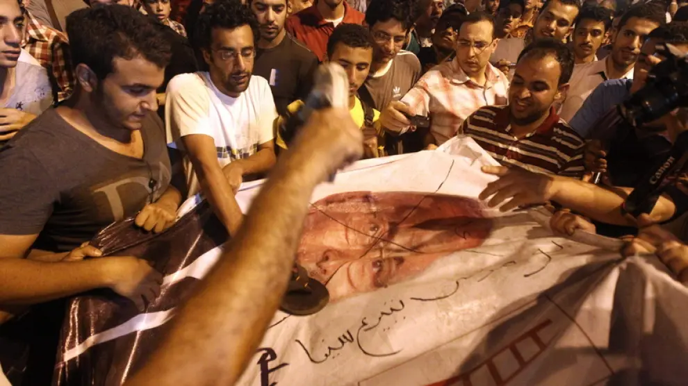 Los manifestantes pintan un cartel del candidato presidencial