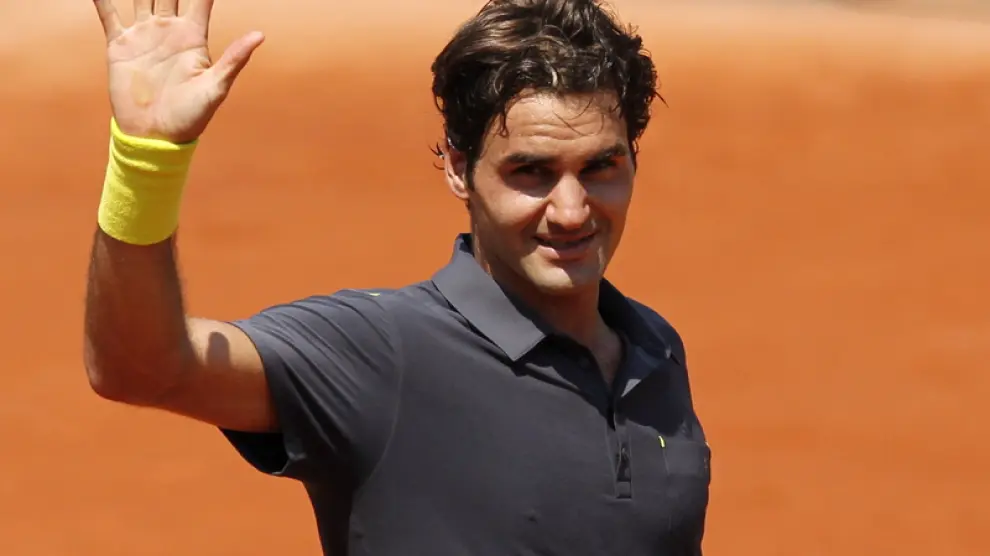 Roger Federer saluda al público tras conseguir su victoria 233 en Gran Slam