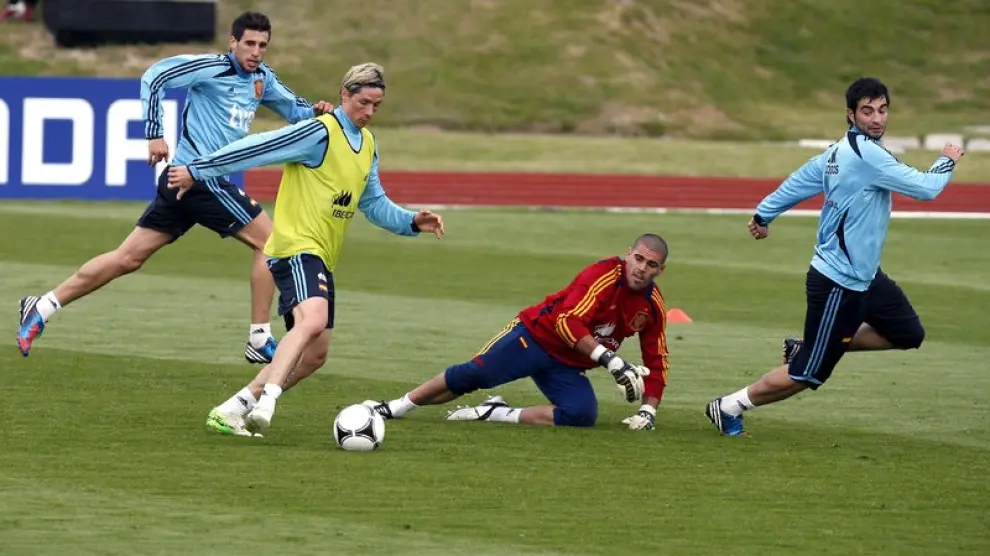 Torres, con el peto verde, encara a Valdés en el entrenamiento