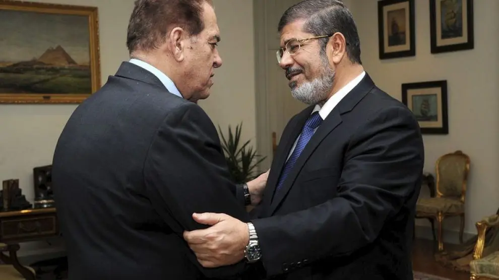 Mohamed Mursi (dcha), saludando al primer ministro saliente, Kamal Ganzouri