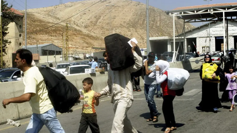 Familias sirias curzan la frontera libanesa con Siria.