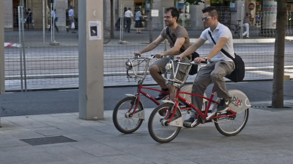 Dos ciclistas circulan por la acera del paseo de la Independencia