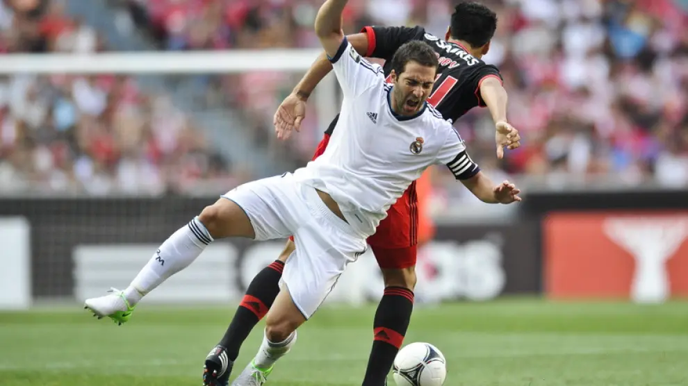 El defensa del Benfica Ezequiel Garay pelea por el balón con Gonzalo Higuaín.