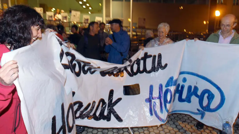 Miembros de ETA Herrira recogen las pancartas colocadas frente al Hospital Donostia.