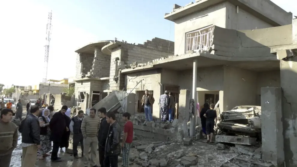 Un grupo de iraquíes inspeccionan el escenario de un ataque con coche bomba en Kirkuk
