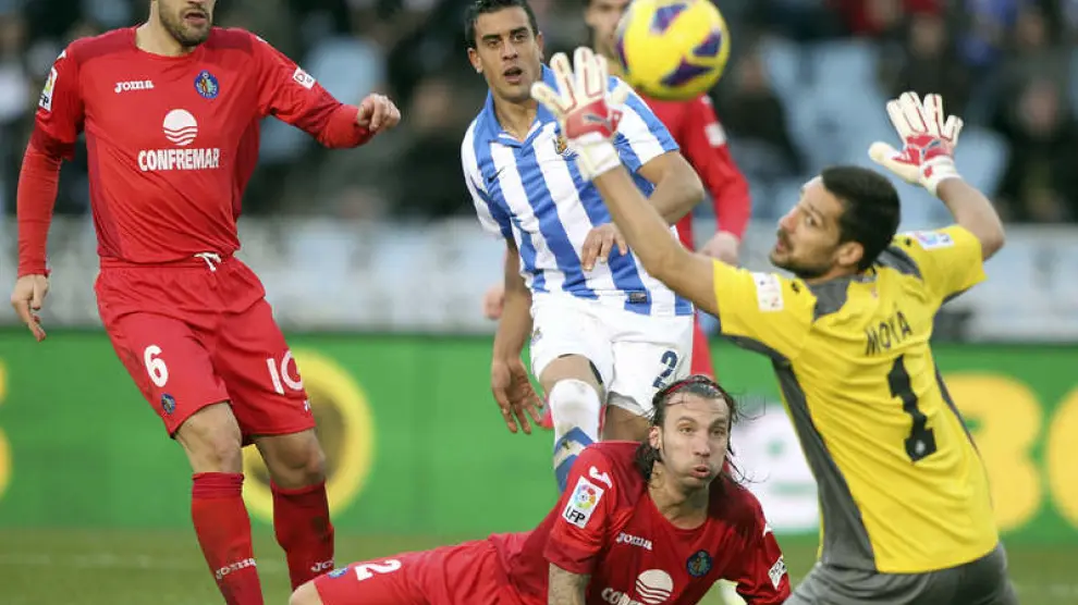 El delantero de la Real Sociedad, Diego Ilfrán (c, detrás) dispara a portería