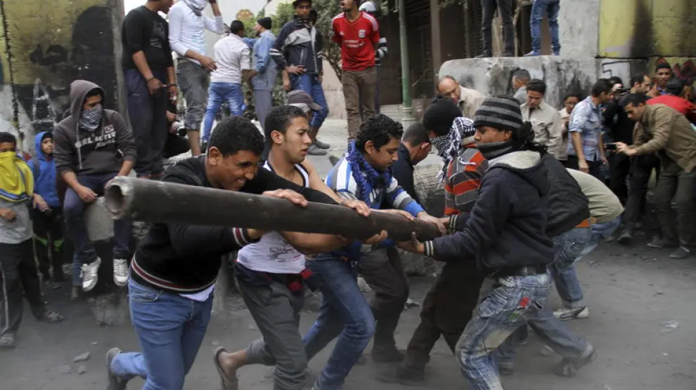 Jóvenes intentan derribar un muro que aísla el Parlamento de la plaza Tahrir