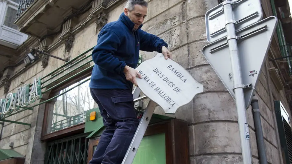 Un operario del Ayuntamiento retira la placa con el nombre antiguo de La Rambla