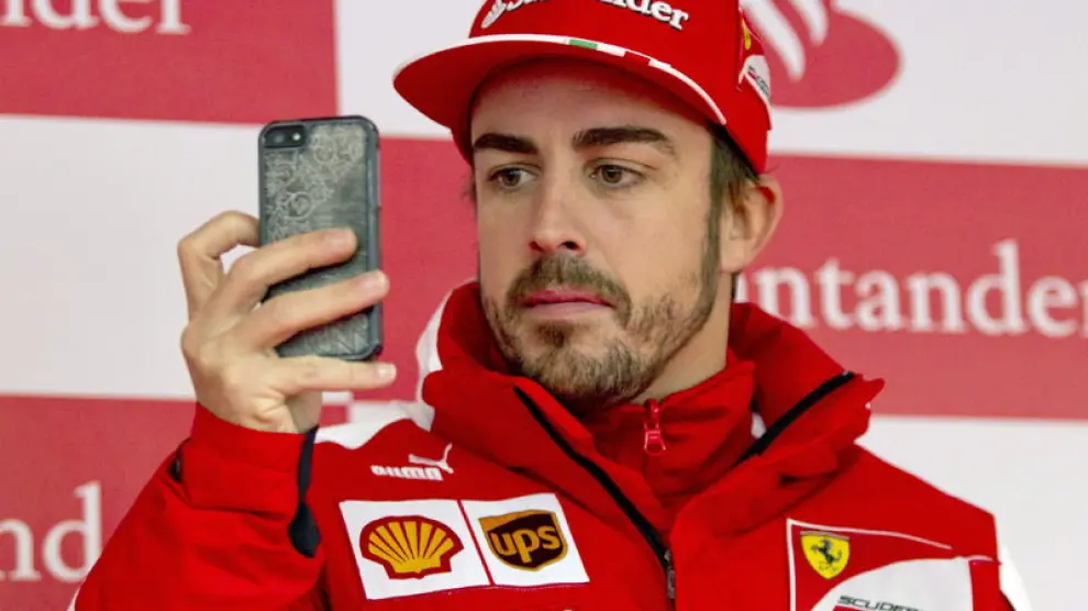 Alonso tomando fotos con su móvil en Montmeló