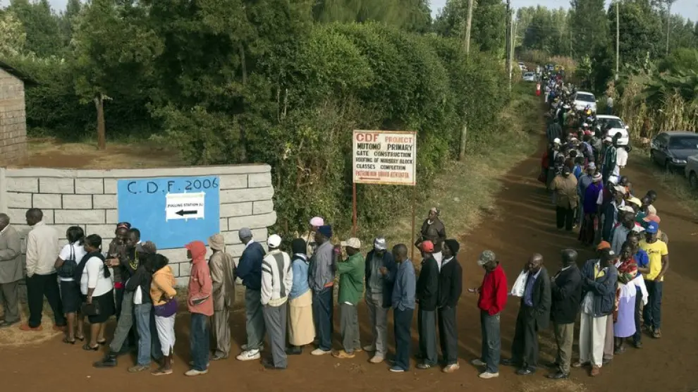 Una larga fila de votantes esperan su turno en uno de los colegios electorales