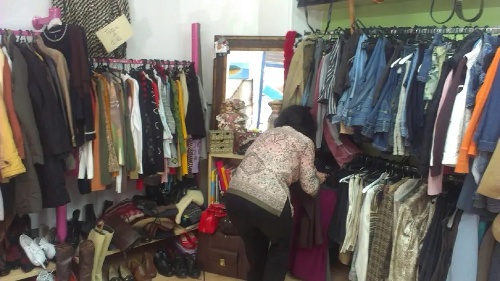 Pilar González, una voluntaria, arregla la ropa expuesta en la tienda.