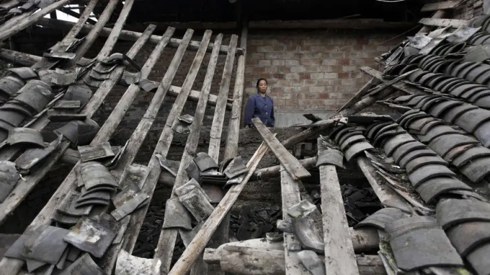 Una mujer contempla las ruinas de su casa tras el terremoto de Sichuan