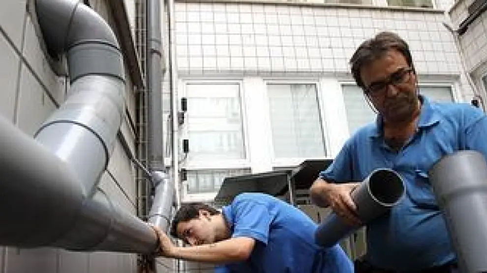 Dos fontaneros montan una instalación. / Jordi Alemany