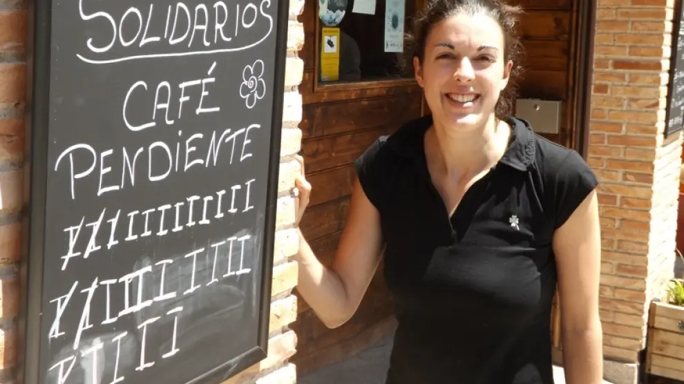 Estefanía Castán, camarera del bar La Fábrica de Huesca, ante la pizarra de cafés pendientes