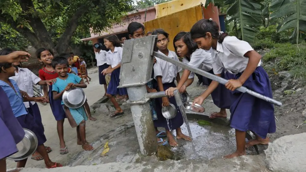 Los niños de una escuela en Chapra lavan sus platos tras recibir la comida del mediodía que proporciona el Gobierno indio
