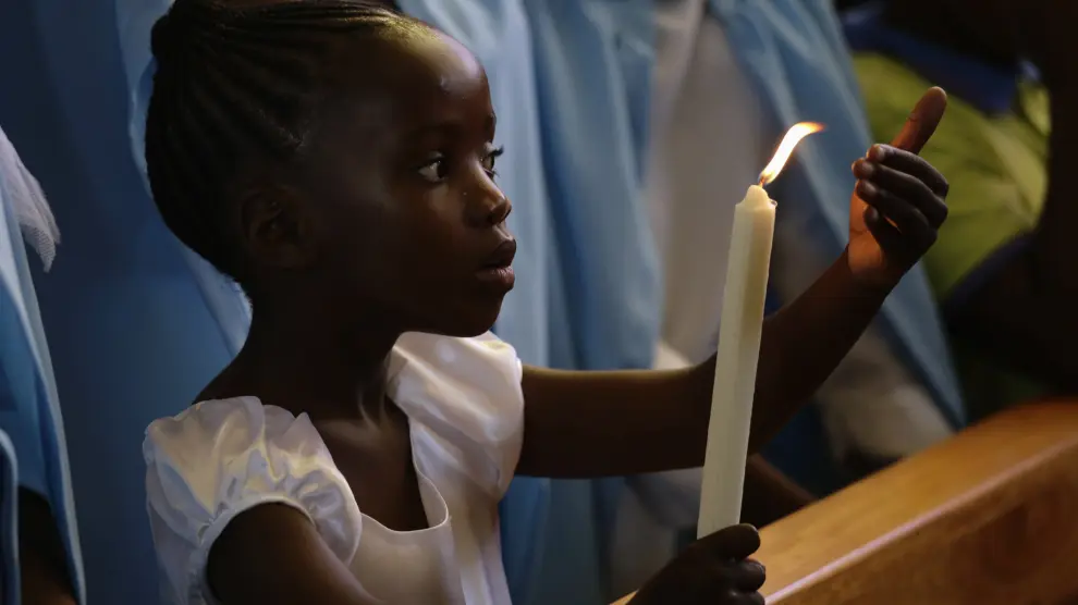 Una niña enciende una vela por Mandela