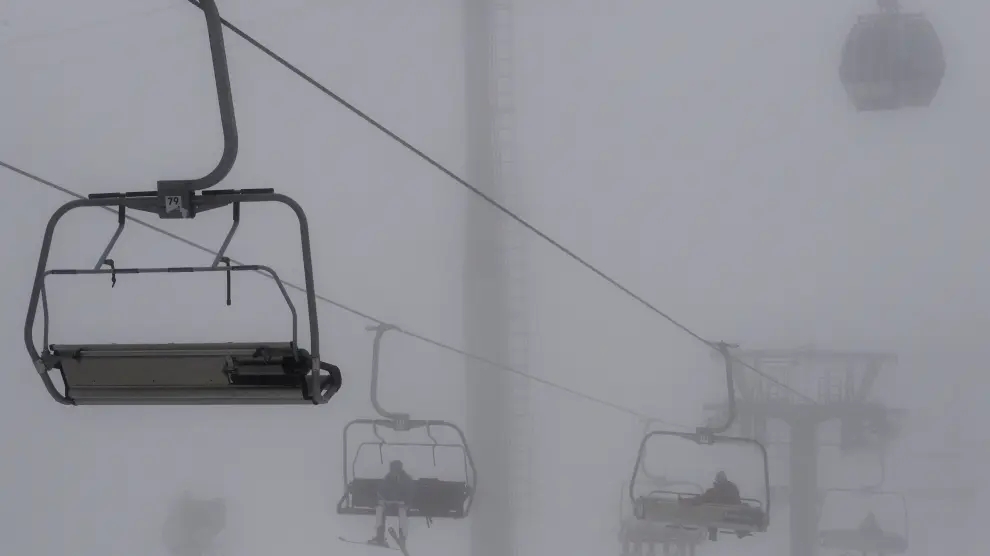 Esquiadores se desplazan a las pistas entre la niebla