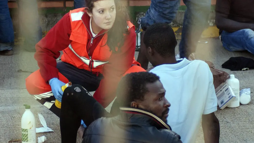Un miembro de Cruz Roja atiende a un inmigrante en Melilla