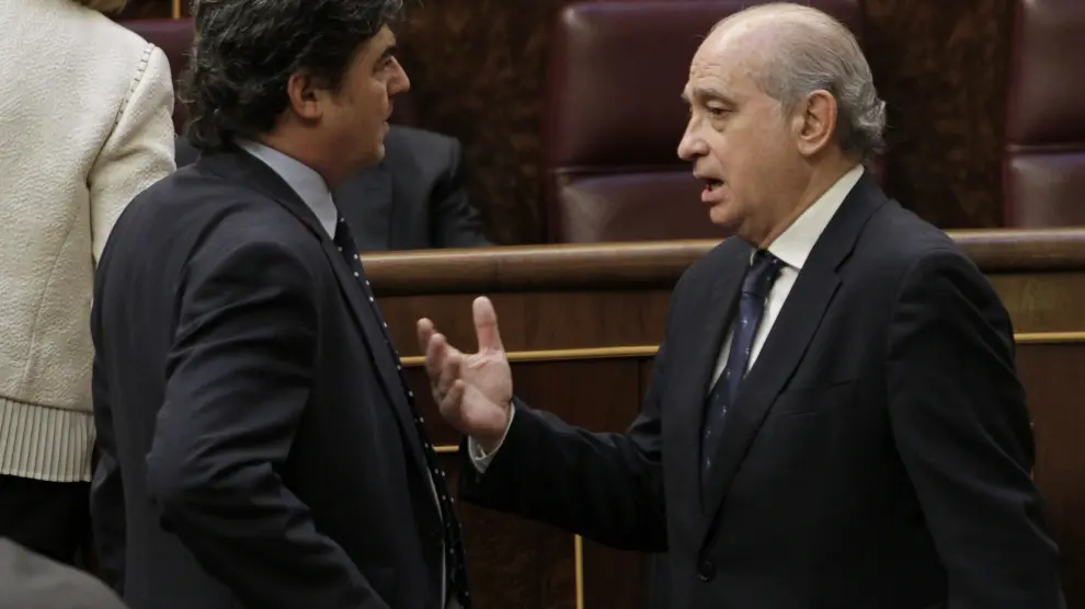 El ministro del Interior, Jorge Fernández Díaz (d), conversa con el director del gabinete del presidente del Gobierno, Jorge Moragas.