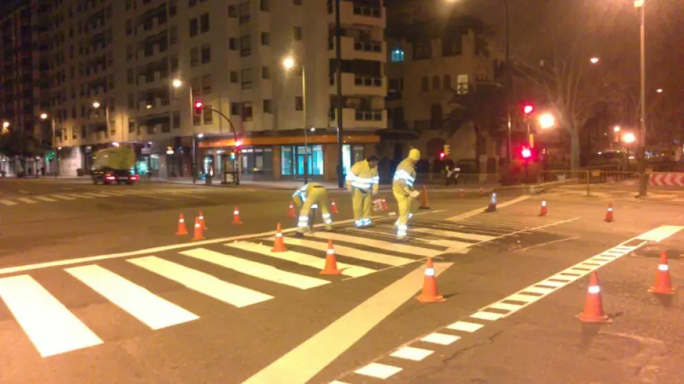 Varios operarios pintaban por la noche el paso de peatones